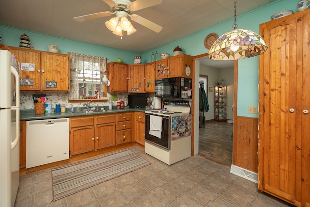 210 1st St SE, Hayfield, MN 55940 - kitchen featuring white appliances, a sink, dark countertops, light flooring, and brown cabinetry