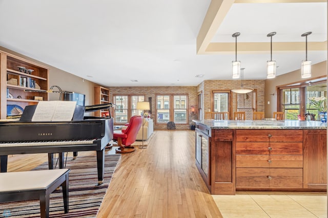 300 Broadway N Unit 204, Fargo, ND 58102 - kitchen with brick wall, healthy amount of natural light, light stone countertops, and pendant lighting