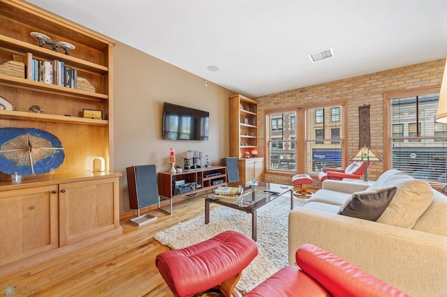 300 Broadway N Unit 204, Fargo, ND 58102 - living room featuring light wood finished floors, brick wall, and built in features