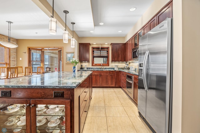 300 Broadway N Unit 204, Fargo, ND 58102 - kitchen featuring stainless steel appliances, decorative backsplash, dark stone countertops, and hanging light fixtures