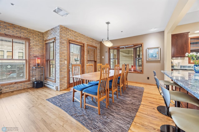 300 Broadway N Unit 204, Fargo, ND 58102 - dining space featuring brick wall, light wood-style flooring, baseboards, and baseboard heating