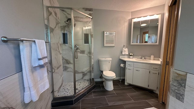 full bath with a marble finish shower, vanity, toilet, and tile patterned floors