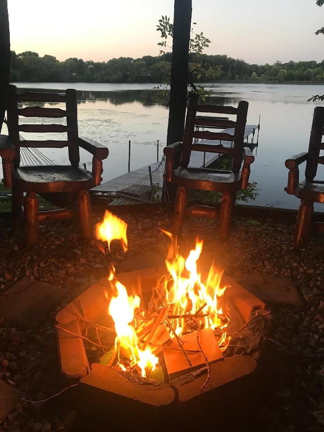 dock with an outdoor fire pit and a water view