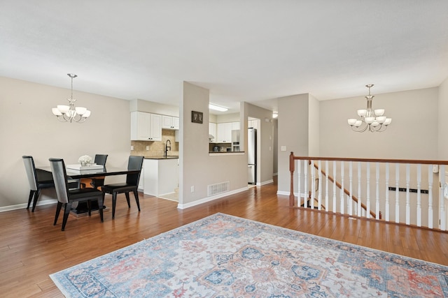 13967 Herald Ct, Apple Valley, MN 55124 - dining room featuring a chandelier, wood finished floors, and baseboards