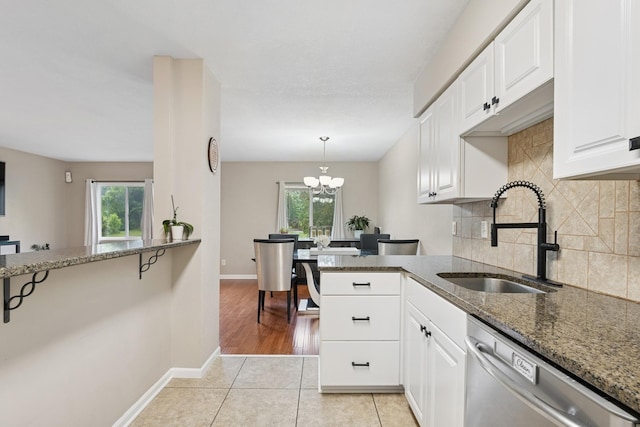 13967 Herald Ct, Apple Valley, MN 55124 - kitchen featuring stainless steel dishwasher, a sink, dark stone countertops, and white cabinetry