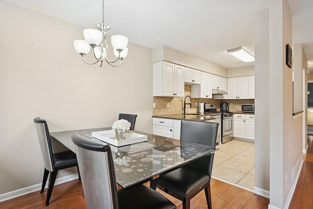13967 Herald Ct, Apple Valley, MN 55124 - dining area featuring a chandelier, light wood-type flooring, and baseboards