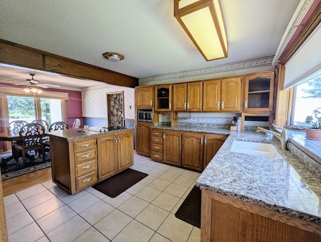 24944 State Highway 210, Mcgregor, MN 55760 - kitchen with a sink, stainless steel microwave, brown cabinets, a textured ceiling, and plenty of natural light