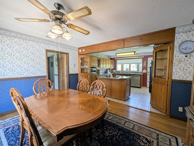 24944 State Highway 210, Mcgregor, MN 55760 - dining area with wallpapered walls, wainscoting, a textured ceiling, and a ceiling fan