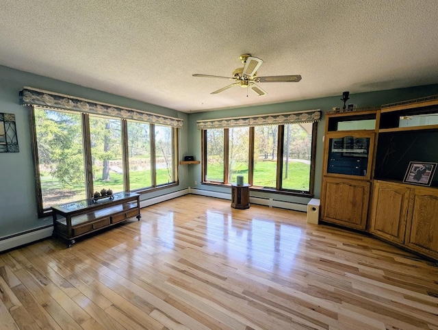 24944 State Highway 210, Mcgregor, MN 55760 - unfurnished living room featuring a textured ceiling, healthy amount of natural light, light wood-type flooring, and a ceiling fan