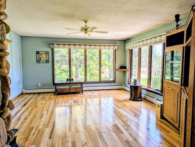 24944 State Highway 210, Mcgregor, MN 55760 - spare room featuring a baseboard heating unit, light wood finished floors, and a textured ceiling