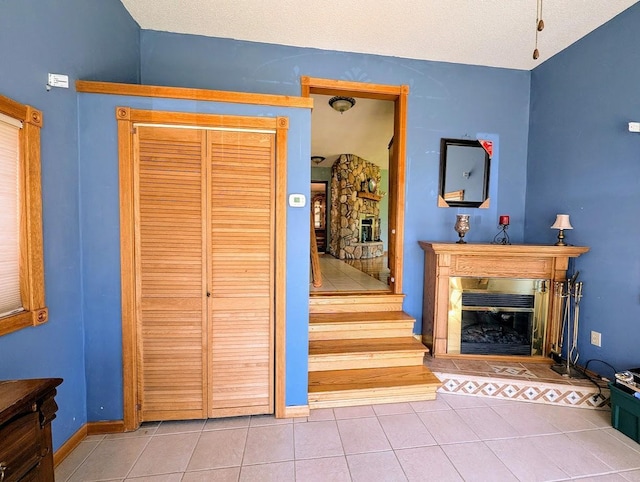 24944 State Highway 210, Mcgregor, MN 55760 - stairway featuring a glass covered fireplace, tile patterned flooring, and vaulted ceiling