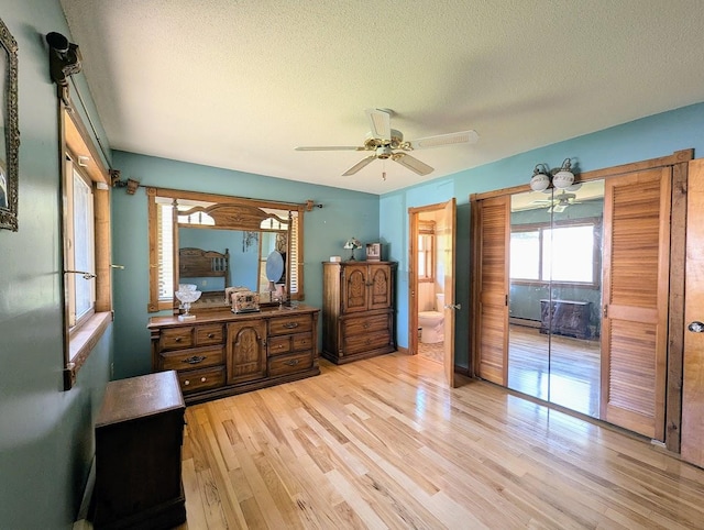 24944 State Highway 210, Mcgregor, MN 55760 - bedroom featuring light wood-style flooring, a textured ceiling, a ceiling fan, and ensuite bath