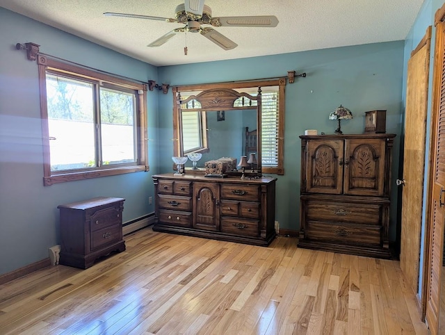 24944 State Highway 210, Mcgregor, MN 55760 - bedroom featuring light wood-style flooring, a baseboard heating unit, multiple windows, and ceiling fan