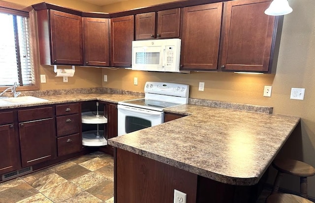 413 River Bluff Dr, Windom, MN 56101 - kitchen with white appliances, a sink, a peninsula, stone finish flooring, and a kitchen bar