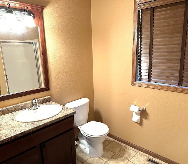 413 River Bluff Dr, Windom, MN 56101 - bathroom featuring a stall shower, baseboards, vanity, toilet, and tile patterned flooring