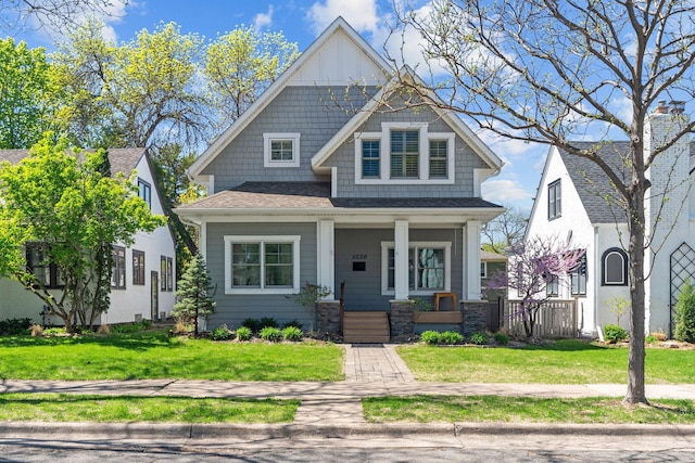 5220 Abbott Ave S, Minneapolis, MN 55410 - view of front facade featuring a porch, a front lawn, roof with shingles, and board and batten siding