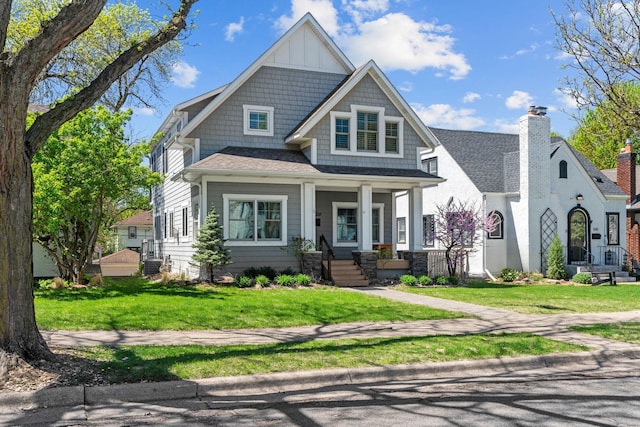 5220 Abbott Ave S, Minneapolis, MN 55410 - view of front of home featuring roof with shingles, covered porch, a front yard, and board and batten siding