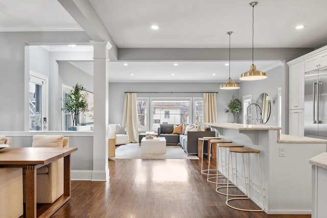 5220 Abbott Ave S, Minneapolis, MN 55410 - kitchen with white cabinetry, a breakfast bar area, dark wood finished floors, stainless steel built in refrigerator, and baseboards