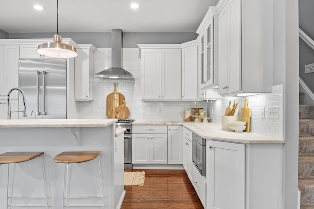 5220 Abbott Ave S, Minneapolis, MN 55410 - kitchen featuring wall chimney exhaust hood, built in appliances, white cabinets, a sink, and recessed lighting