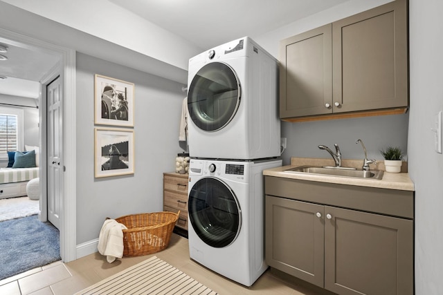 5220 Abbott Ave S, Minneapolis, MN 55410 - clothes washing area featuring estacked washer and dryer, cabinet space, light tile patterned floors, light carpet, and baseboards