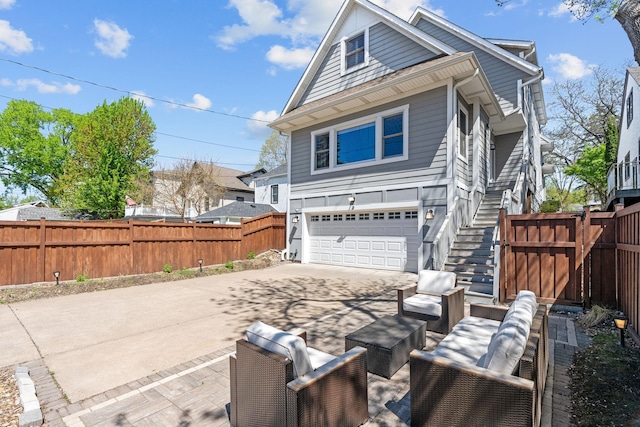 5220 Abbott Ave S, Minneapolis, MN 55410 - view of side of property with driveway, an attached garage, stairway, fence, and outdoor lounge area