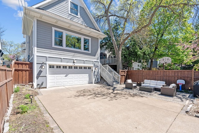 5220 Abbott Ave S, Minneapolis, MN 55410 - view of front of home featuring an attached garage, outdoor lounge area, concrete driveway, and fence