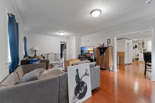 4559 Washington St NE, Columbia Heights, MN 55421 - living room with a textured ceiling, light wood finished floors, crown molding, and healthy amount of natural light