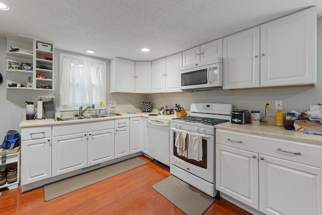 4559 Washington St NE, Columbia Heights, MN 55421 - kitchen featuring white appliances, a textured ceiling, recessed lighting, light wood finished floors, and white cabinets