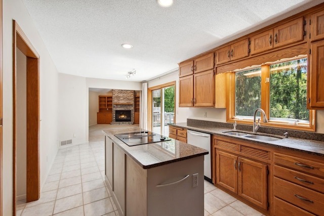 12005 27th Ave N, Plymouth, MN 55441 - kitchen with dishwasher, a center island, black electric cooktop, a large fireplace, and a sink