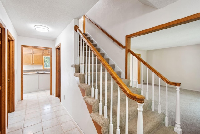 12005 27th Ave N, Plymouth, MN 55441 - staircase with a textured ceiling, baseboards, and tile patterned flooring
