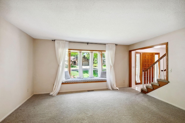 12005 27th Ave N, Plymouth, MN 55441 - empty room featuring a textured ceiling, carpet flooring, stairs, and baseboards