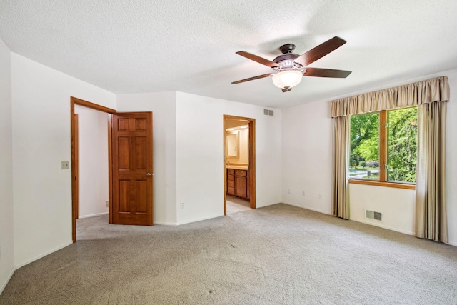 12005 27th Ave N, Plymouth, MN 55441 - unfurnished bedroom featuring light colored carpet, baseboards, connected bathroom, a textured ceiling, and a ceiling fan