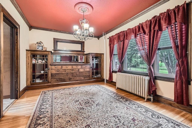 15947 Scandia Trl N, Scandia, MN 55073 - unfurnished dining area with radiator, crown molding, a chandelier, wood finished floors, and baseboards