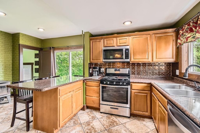 15947 Scandia Trl N, Scandia, MN 55073 - kitchen with appliances with stainless steel finishes, a sink, backsplash, a breakfast bar, and brick wall