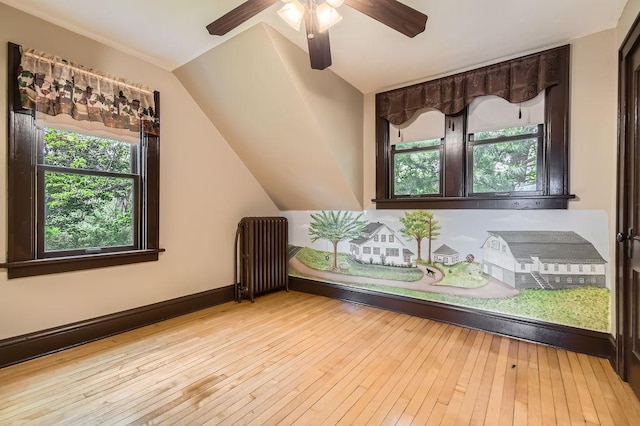 15947 Scandia Trl N, Scandia, MN 55073 - empty room with radiator heating unit, plenty of natural light, ceiling fan, vaulted ceiling, and hardwood / wood-style flooring