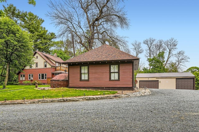 15947 Scandia Trl N, Scandia, MN 55073 - view of home's exterior with an outdoor structure, a detached garage, a shingled roof, and a yard