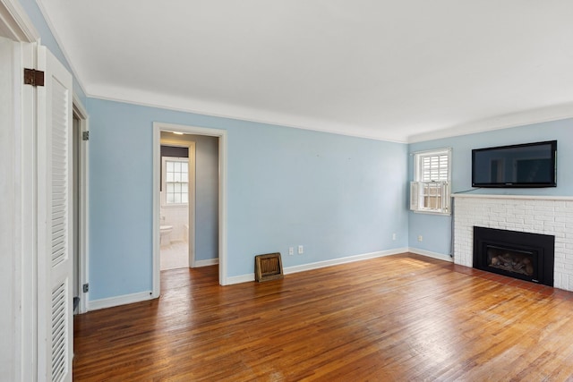 4150 Beard Ave N, Robbinsdale, MN 55422 - unfurnished living room with wood finished floors, a brick fireplace, and crown molding