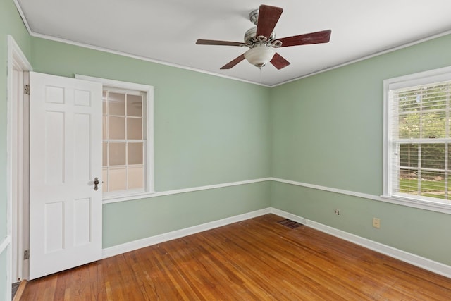 4150 Beard Ave N, Robbinsdale, MN 55422 - empty room featuring crown molding, wood finished floors, healthy amount of natural light, and a ceiling fan