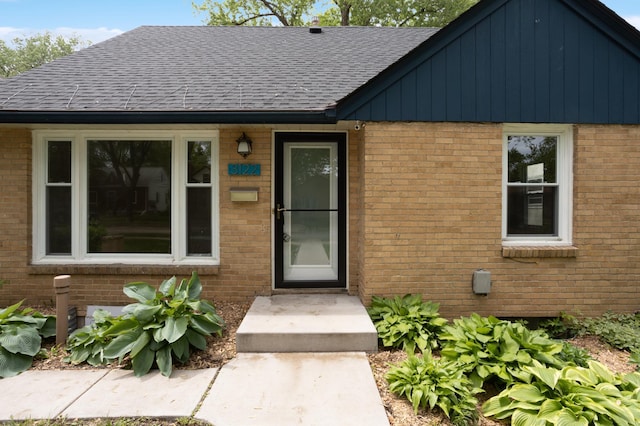 3122 Arthur St NE, Minneapolis, MN 55418 - property entrance featuring brick siding, roof with shingles, and board and batten siding
