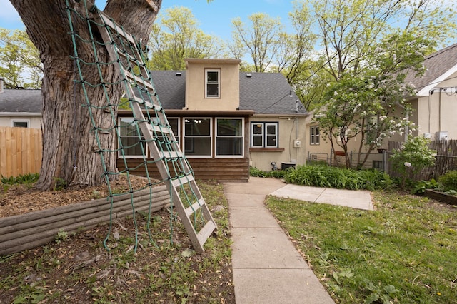 3122 Arthur St NE, Minneapolis, MN 55418 - back of house with stucco siding, roof with shingles, and a sunroom