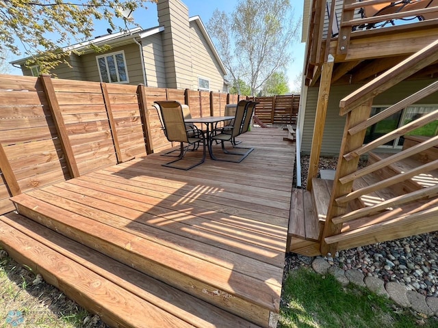 wooden deck featuring outdoor dining area and a fenced backyard