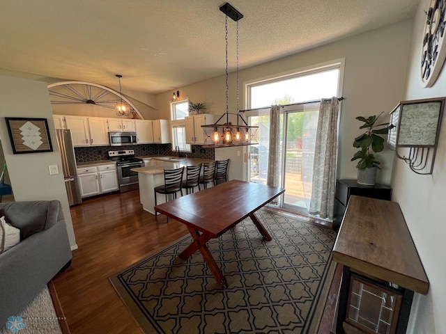 dining space with dark wood-style floors and a chandelier
