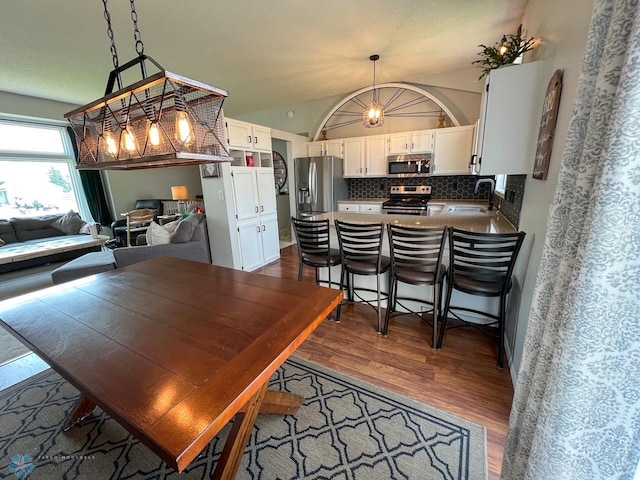 dining room featuring dark wood-style floors and lofted ceiling