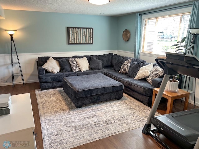 living room with a textured ceiling and dark wood-style floors