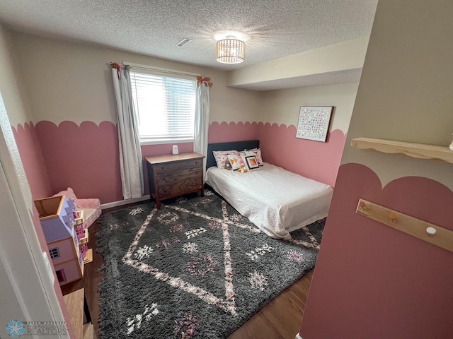 bedroom featuring a textured ceiling and wood finished floors