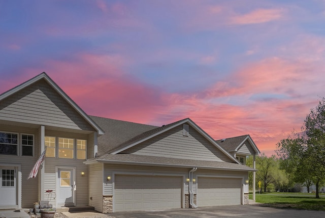 5678 Sherman Oaks Rd, Stacy, MN 55079 - view of front of home featuring an attached garage, driveway, a shingled roof, and stone siding