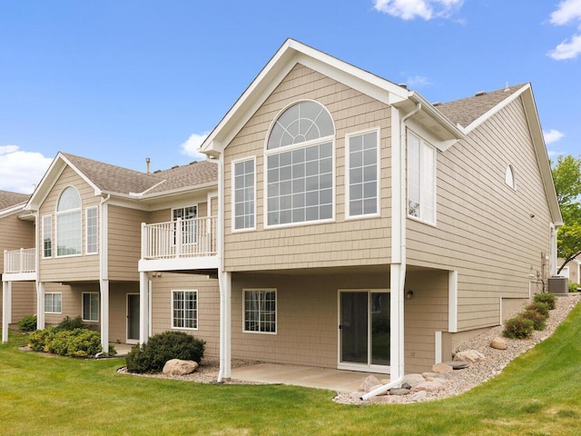 663 Regent Ln, Waconia, MN 55387 - rear view of property featuring central AC unit, a yard, a patio area, roof with shingles, and a balcony