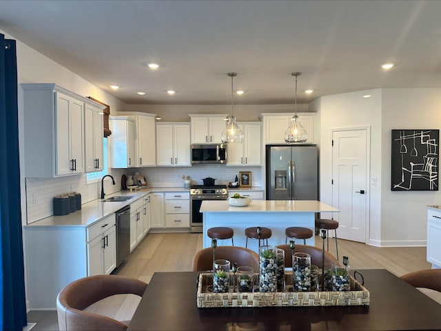 14536 74th St NE, Otsego, MN 55330 - kitchen with appliances with stainless steel finishes, light wood finished floors, a sink, light countertops, and decorative backsplash