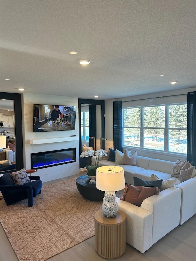 14536 74th St NE, Otsego, MN 55330 - living area featuring a textured ceiling, a glass covered fireplace, and recessed lighting