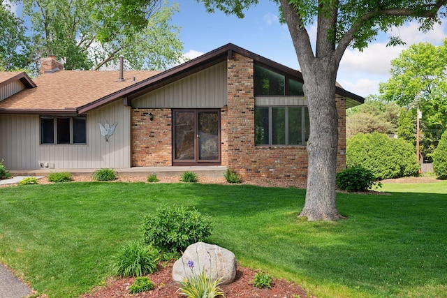 3291 Hillsboro Ave S, Saint Louis Park, MN 55426 - mid-century inspired home featuring a chimney, board and batten siding, a front yard, brick siding, and roof with shingles